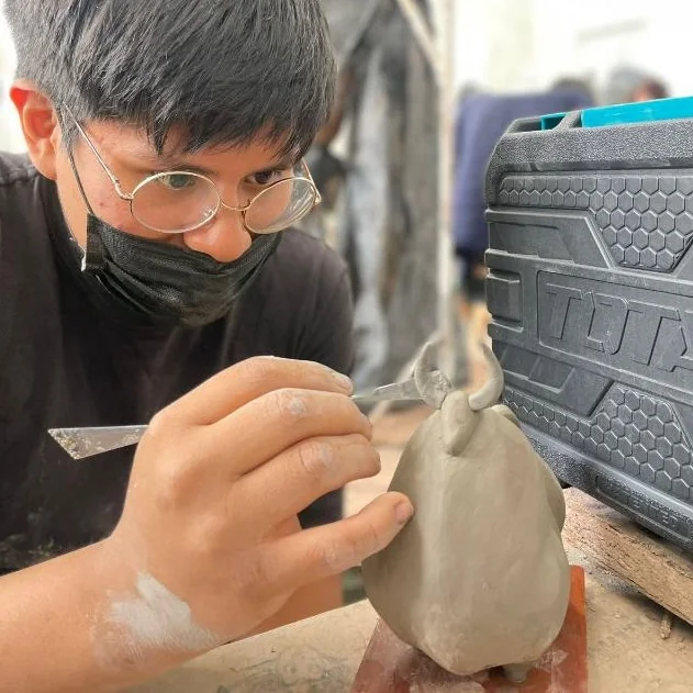 Un integrante del taller modela una pieza de arcilla