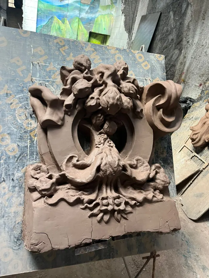 Ornamento barroco en arcilla con flores y volutas
