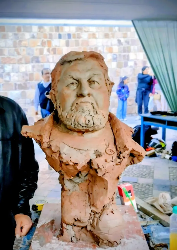 Busto de hombre con barba en arcilla roja, en una exposición