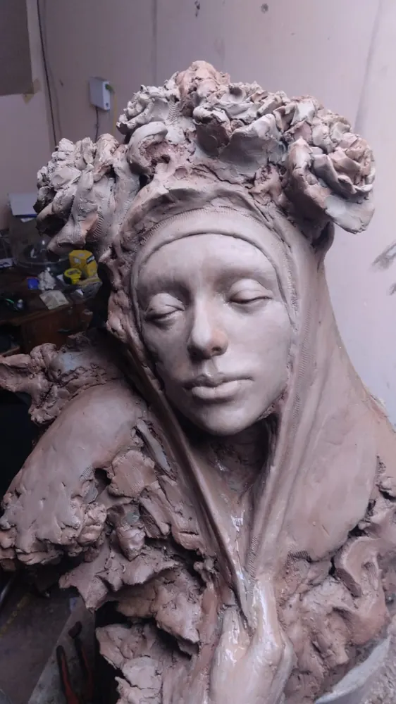 Busto de mujer con corona de flores, en arcilla