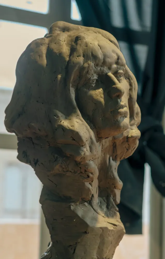 Busto de mujer con cabello ondulado, en arcilla